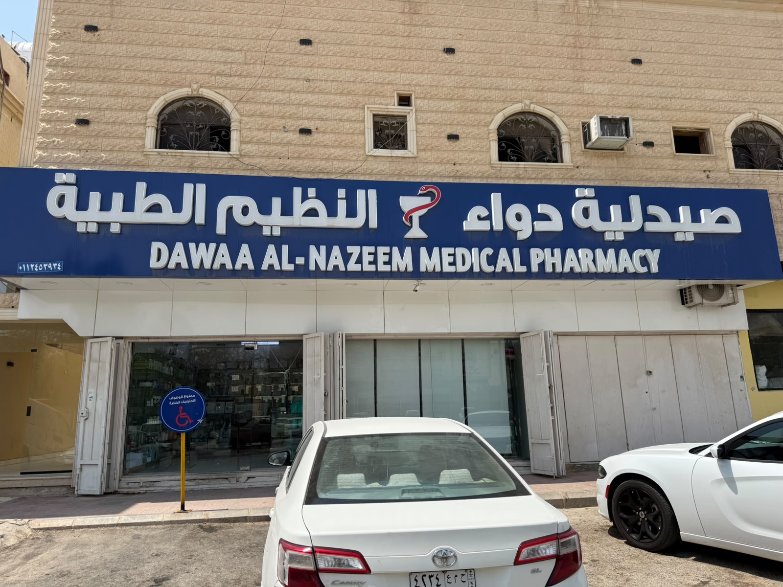 Dawaa Al-Nazeem Medical Pharmacy storefront with its blue signboard — صيدلية دواء النظيم الطبية